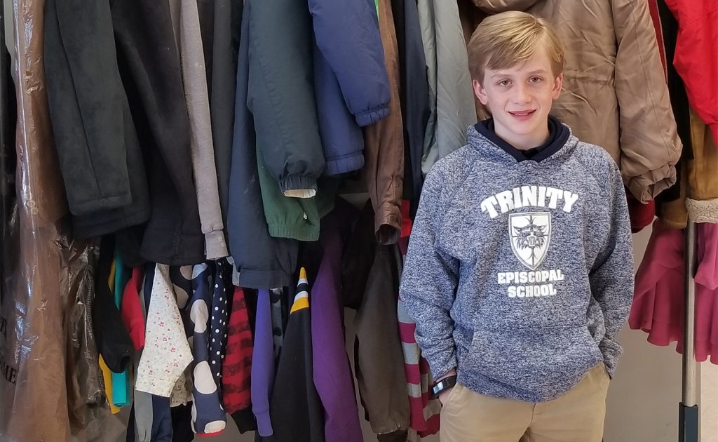 Happy 11 yo poses in Free Store wearing Trinity Episcopal School sweatshirt.