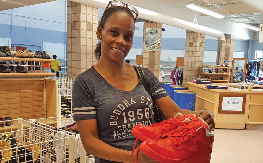 Smiling woman in store holding tennis shoes