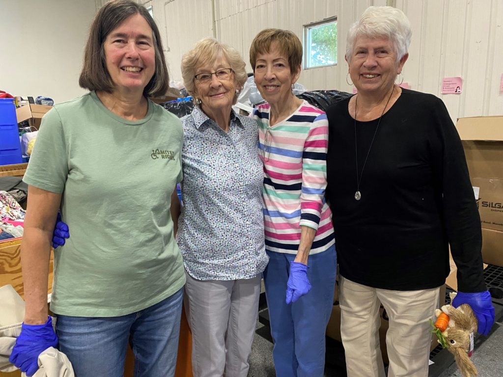 Group of older friends smiling inside the warehouse at Crisis Assistance Ministry