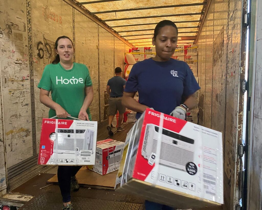 women unload air conditioners from truck