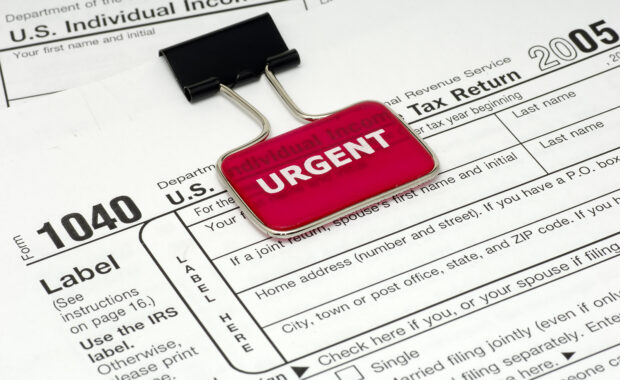 Image of IRS 1040 Individual Tax Form with a binder clip that has a bright red background marker with white words that read "Urgent"