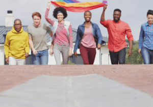 Still Image of Happy Group Of Diverse Male And Female Protesters Walking With Rainbow Flag