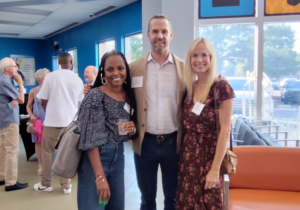 Group of people standing and talking in the Crisis Assistance Ministry lobby during the 2025 alumni event
