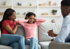 Black girl with behavioral disorder having therapy session with psychologist